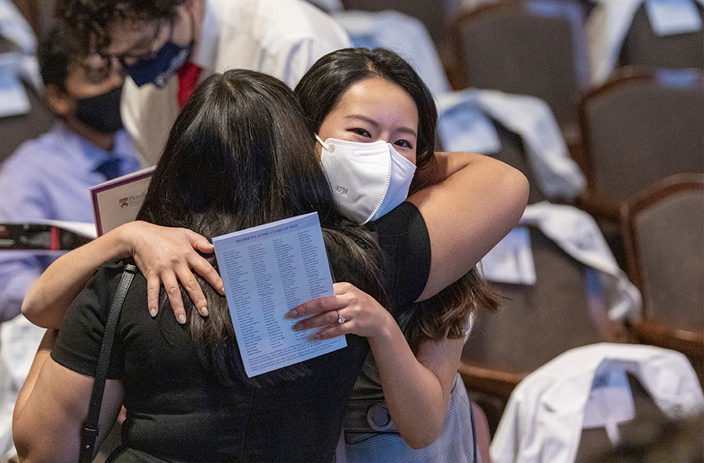 Medical students embrace loved ones at the white coat ceremony